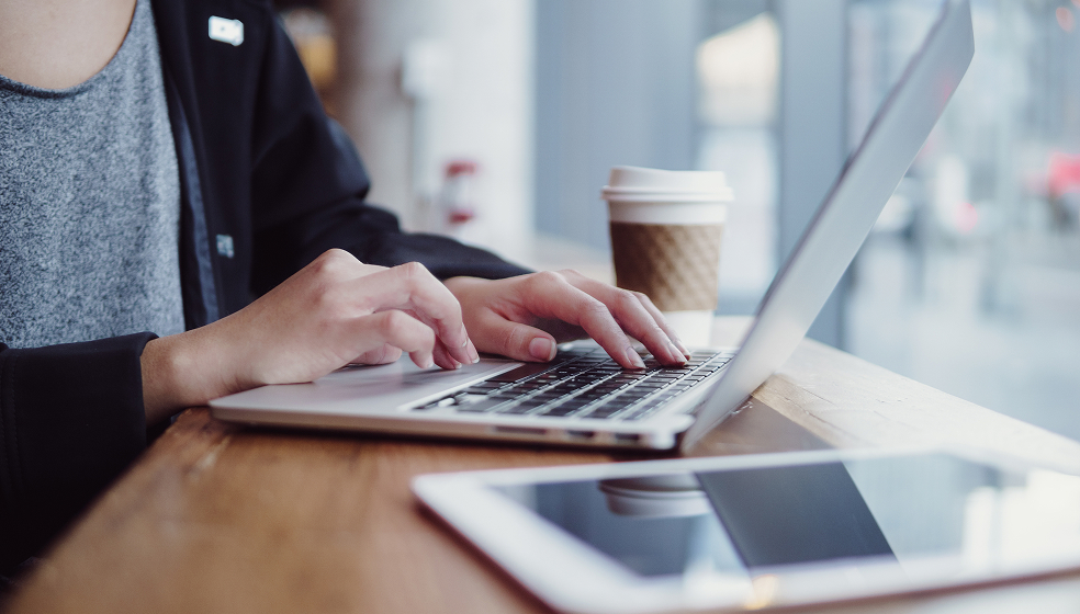 Nahaufnahme einer Person, die am Laptop arbeitet