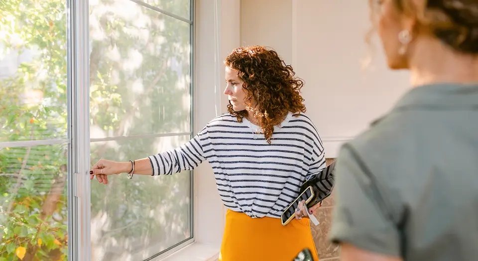 Zwei Frauen im Büro schauen zum Fenster hinaus